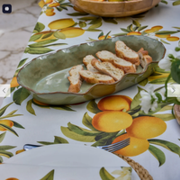 Thumbnail for Marseille green wavy oval dish holding sliced baguette on a citrus print tablecloth