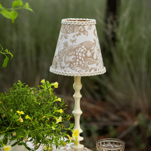Luxe & Beau gold toile lamp shade on a cream lamp base in a garden setting – alternate view