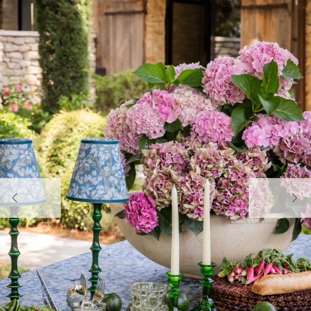 Luxe & Beau navy tapestry lamp shades on an outdoor table with pink hydrangeas – alternate view