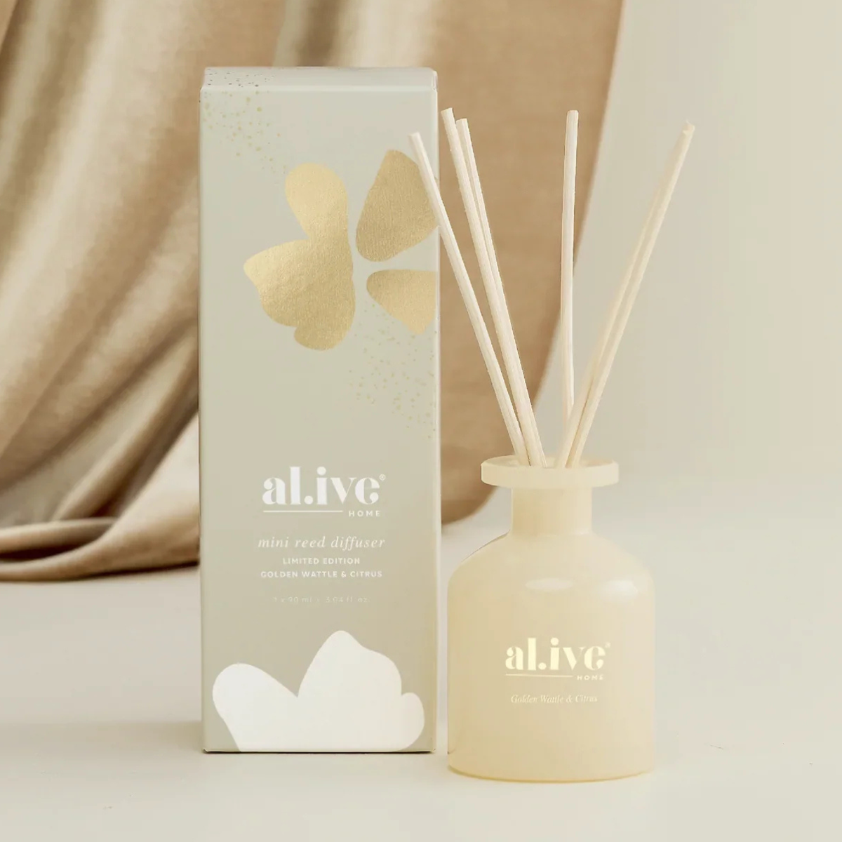al.ive body Mini Reed Diffuser in Golden Wattle and Citrus, butter glass vessel with reeds, shown with its gift box