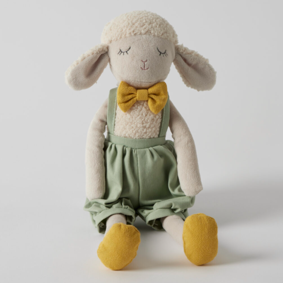 Stanley plush sheep soft toy with a cream fleece body, dressed in a sage green outfit with mustard shoes