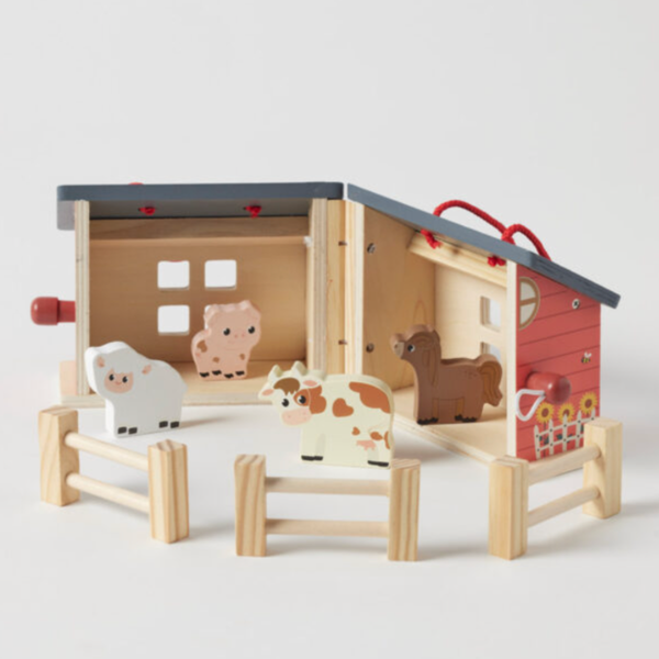 Foldable farmhouse baby toy opened, showing the furnished interior rooms