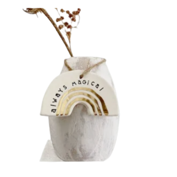 Decorative vase with rainbow design and text 'Always Magical' on a white background