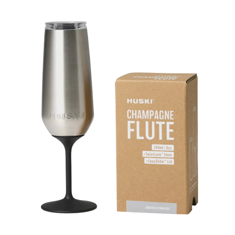 Silver champagne flute with black base next to its packaging box on a white background
