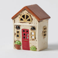 Thumbnail for Fairleigh Cottage Tealight Holder – ceramic house figurine with cream facade, brown roof, red door, and green plant accents