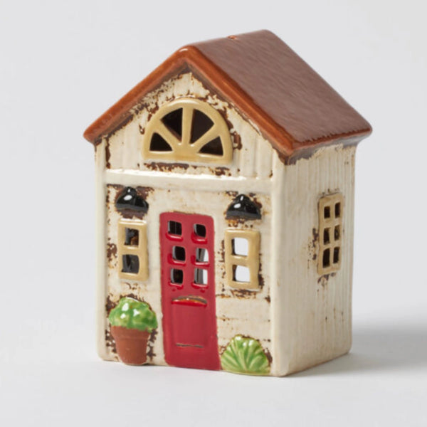 Fairleigh Cottage Tealight Holder – ceramic house figurine with cream facade, brown roof, red door, and green plant accents