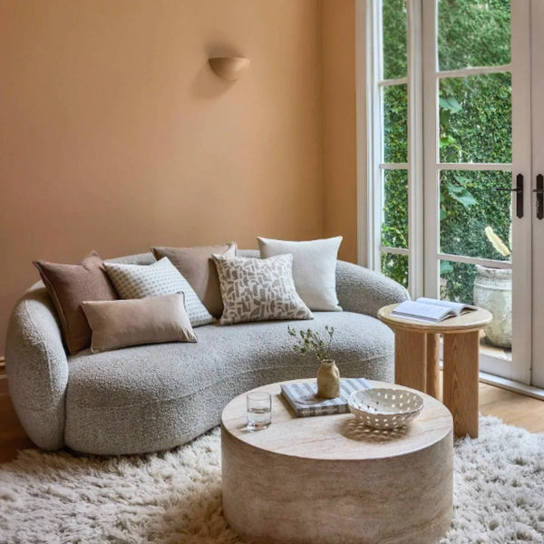 Modern living room with a gray sofa, round coffee table, and large window.